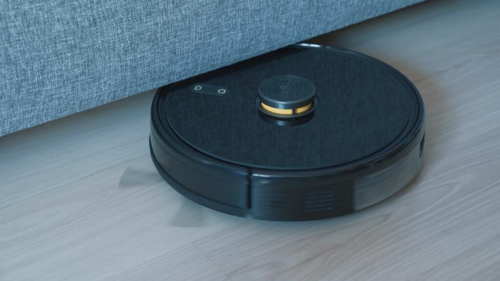 a black robot vacuum on a wooden floor